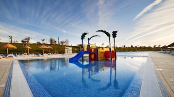 Una piscina techada, una piscina al aire libre de temporada, sombrillas