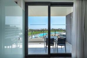 A balcony with a view of a swimming pool and a cityscape.