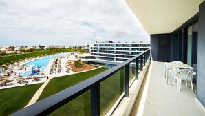A balcony with a view of a swimming pool and a building with multiple floors. - RR Alvor Baía Resort (Portimão)
