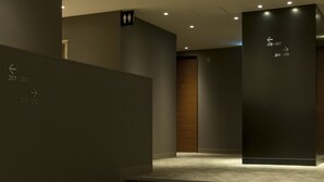 A modern staircase with directional signs indicating room numbers 201-203 and 205-210. - Agora Place Tokyo Asakusa (Tokyo)