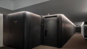 A corridor with dark wooden doors, each marked with room numbers. - Myhotel CMYK Ratchada (Bangkok)