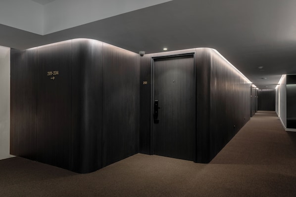 A corridor with dark wooden doors, each marked with room numbers.