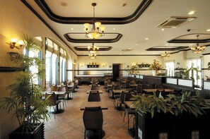 A spacious restaurant with high ceilings, multiple chandeliers, and numerous tables and chairs. - Naha Beach Side Hotel (Naha)