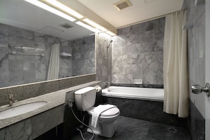 A modern bathroom with a marble sink, toilet, and bathtub. - Ten Stars Hotel Pratunam (Bangkok)