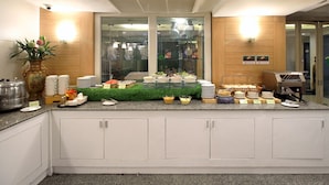 A kitchen area with a buffet setup, including various food items and utensils. - Ten Stars Hotel Pratunam (Bangkok)
