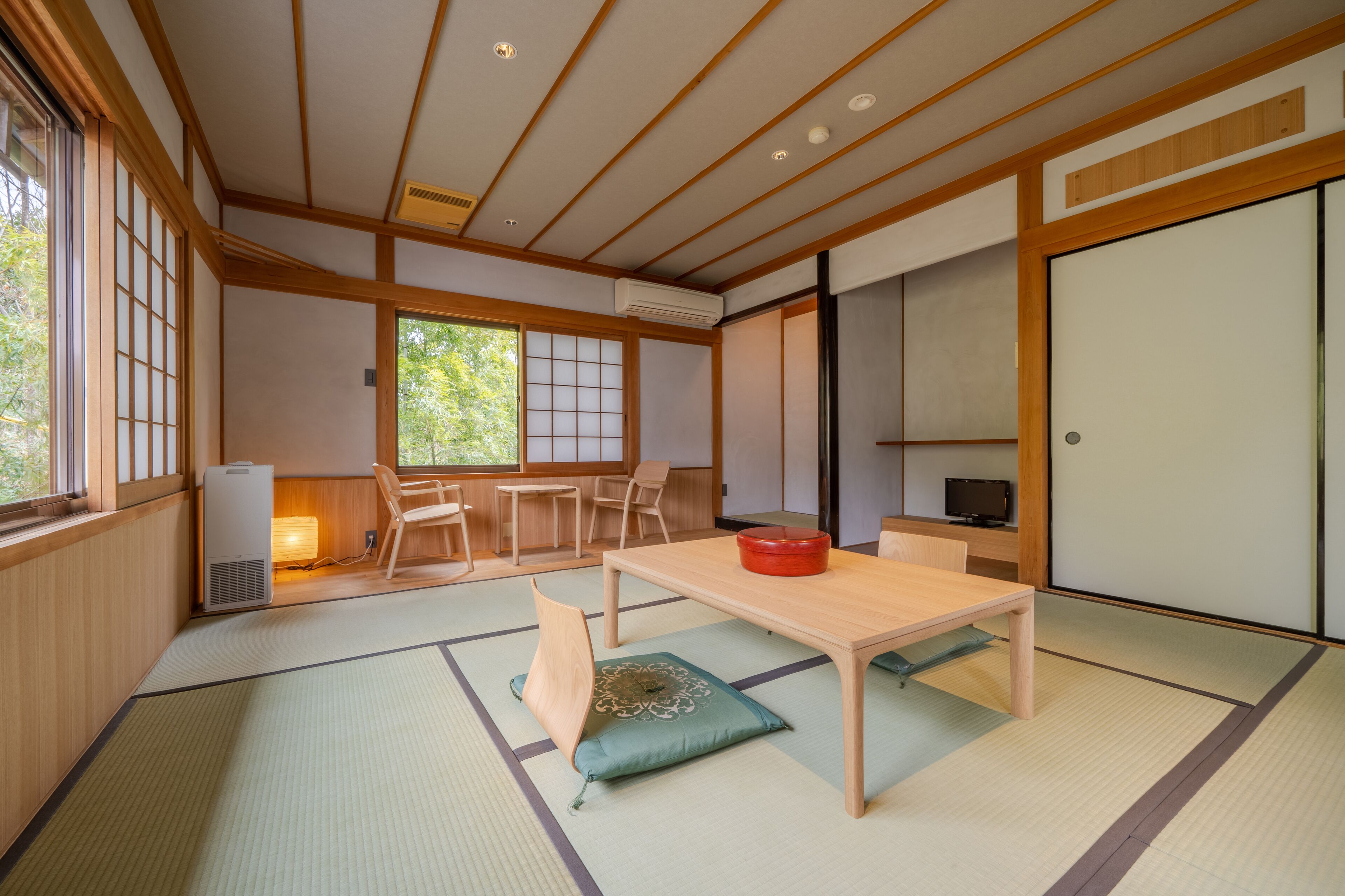 A traditional Japanese room with tatami flooring, a low wooden table, and sliding doors.
