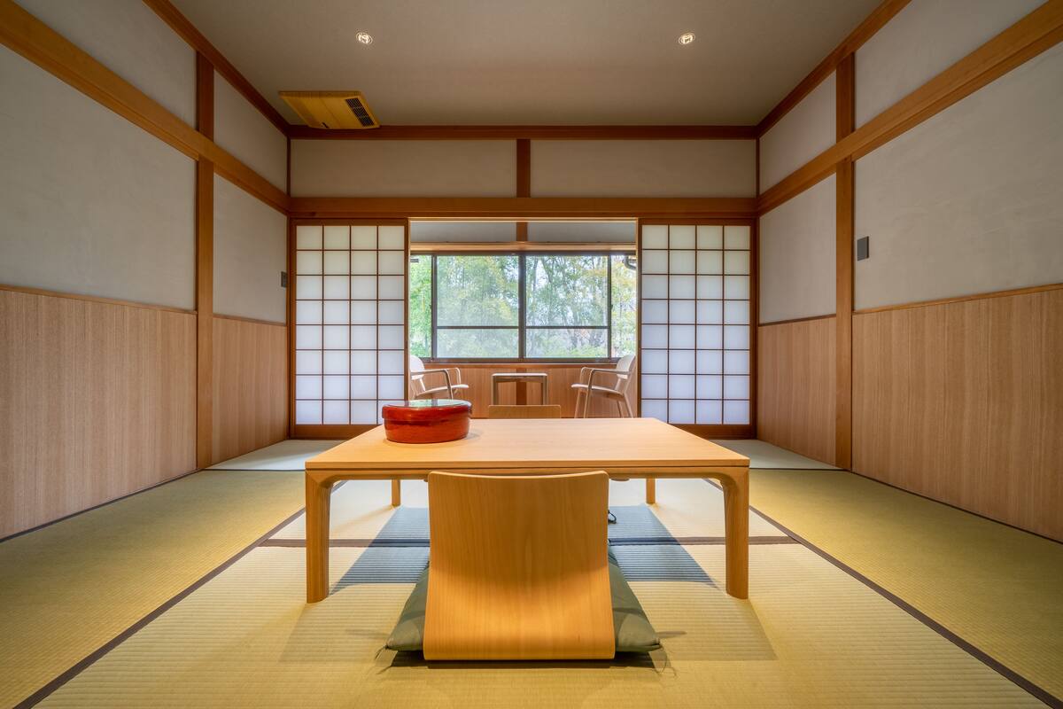 A traditional Japanese room with tatami flooring, a low table, and sliding doors.