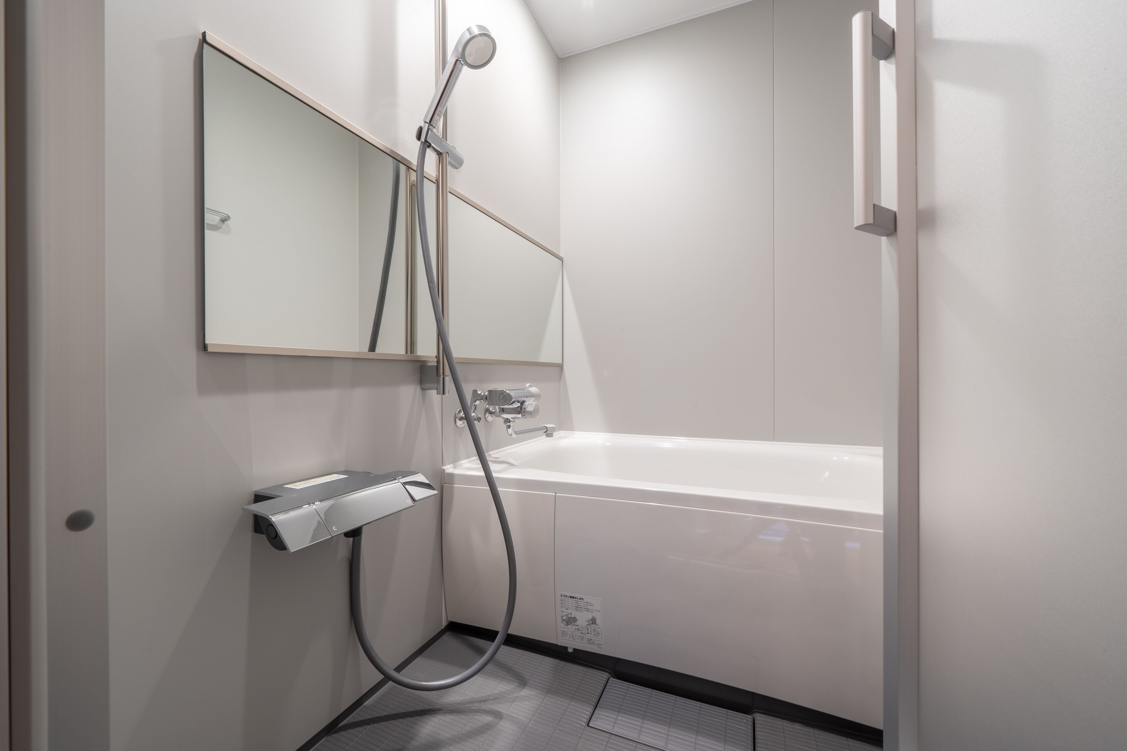 Un baño moderno con bañera, ducha y secador de manos.