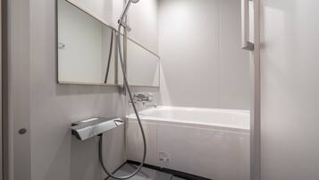 Une salle de bain moderne équipée d’une baignoire, d’une douche et d’un sèche-mains.