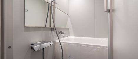 Un baño moderno con bañera, ducha y secador de manos.