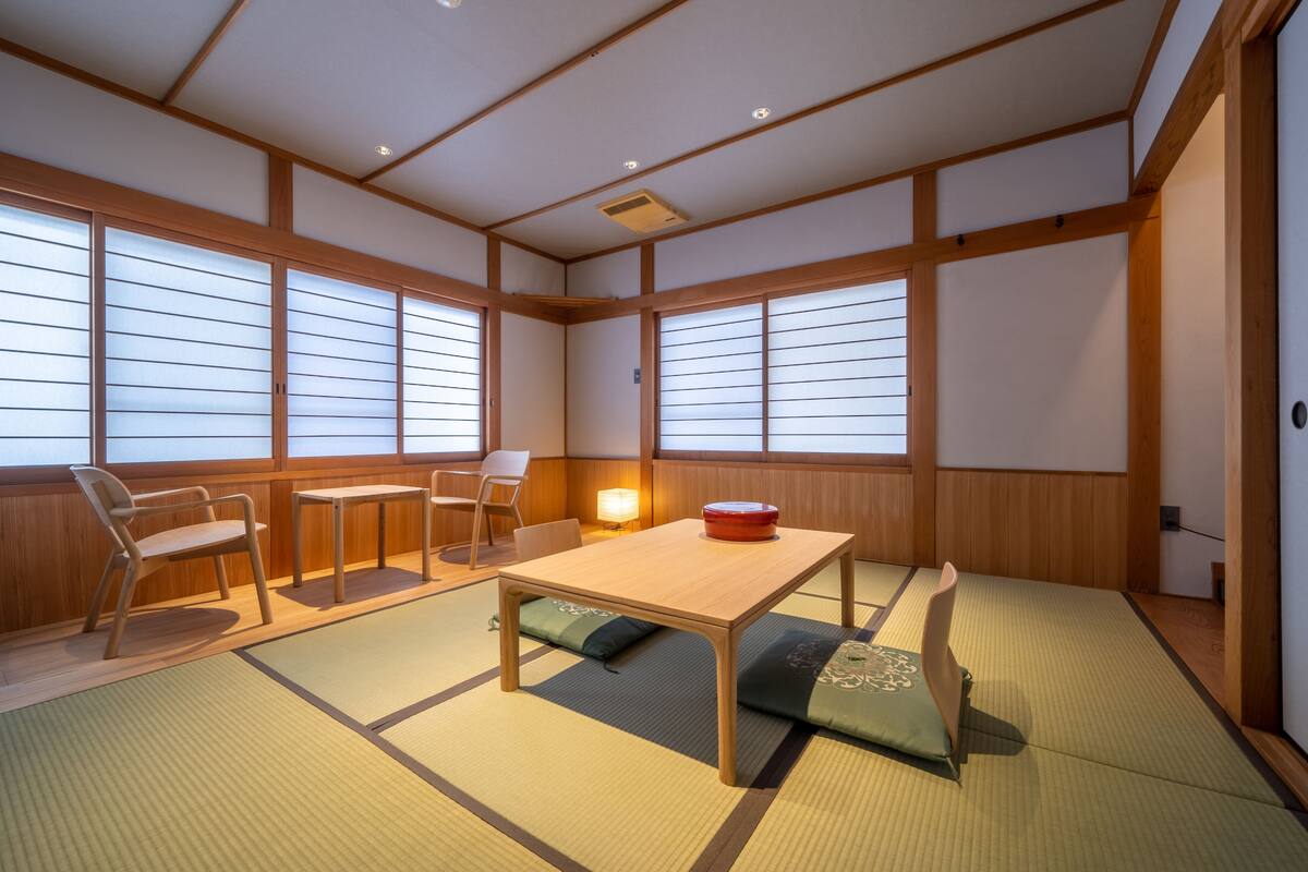 A traditional Japanese room with tatami flooring, a low wooden table, and sliding doors.