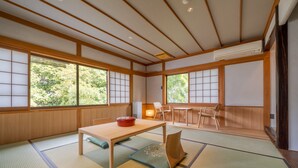 A traditional Japanese room with tatami flooring, a low table, and sliding doors.