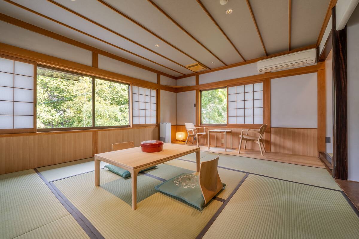 A traditional Japanese room with tatami flooring, a low table, and sliding doors.