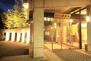 A building entrance with a sign in a foreign language, glass doors, and a tiled floor. - Shisuitei (Numata)