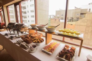 A breakfast buffet with various food items and a coffee machine. - Hotel Stefanos Miraflores (Lima)