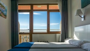 A hotel room with a bed, a window with curtains, a painting on the wall, and a lamp. - Hotel Los Jazmines (Torremolinos)
