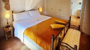 A bedroom with a bed, bedside lamps, a canopy, a wardrobe, and a chair. - Arianella B&B Penedes (Torrelles de Foix)