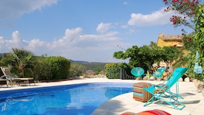 A swimming pool with lounge chairs and a view of a mountain. - Arianella B&B Penedes (Torrelles de Foix)