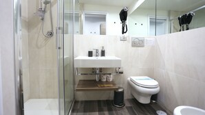 A modern bathroom with a glass shower enclosure, a white sink, a toilet, and a bidet. - B&B Home 77 (Rome)