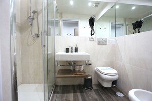 Enjoy a refreshing shower in the bathroom, featuring a glass-enclosed shower, sink, and toilet.
