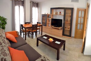 A living room with a sofa, coffee table, TV, and entertainment unit.