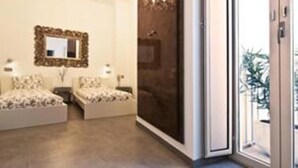 A bedroom with two beds, a chandelier, a mirror, and a sliding glass door leading to a balcony. - Hotel Palacio Alcazar (Seville)