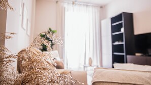 A modern living room with a sofa, a coffee table, and a bookshelf. - AZZ Sevilla Torre de la Plata (Seville)
