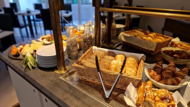 En buffet med forskellige brød, kager og frugter.