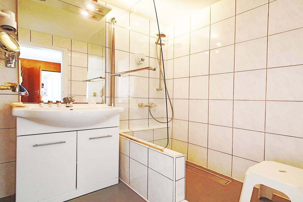 shower, hair dryer, slippers, towels