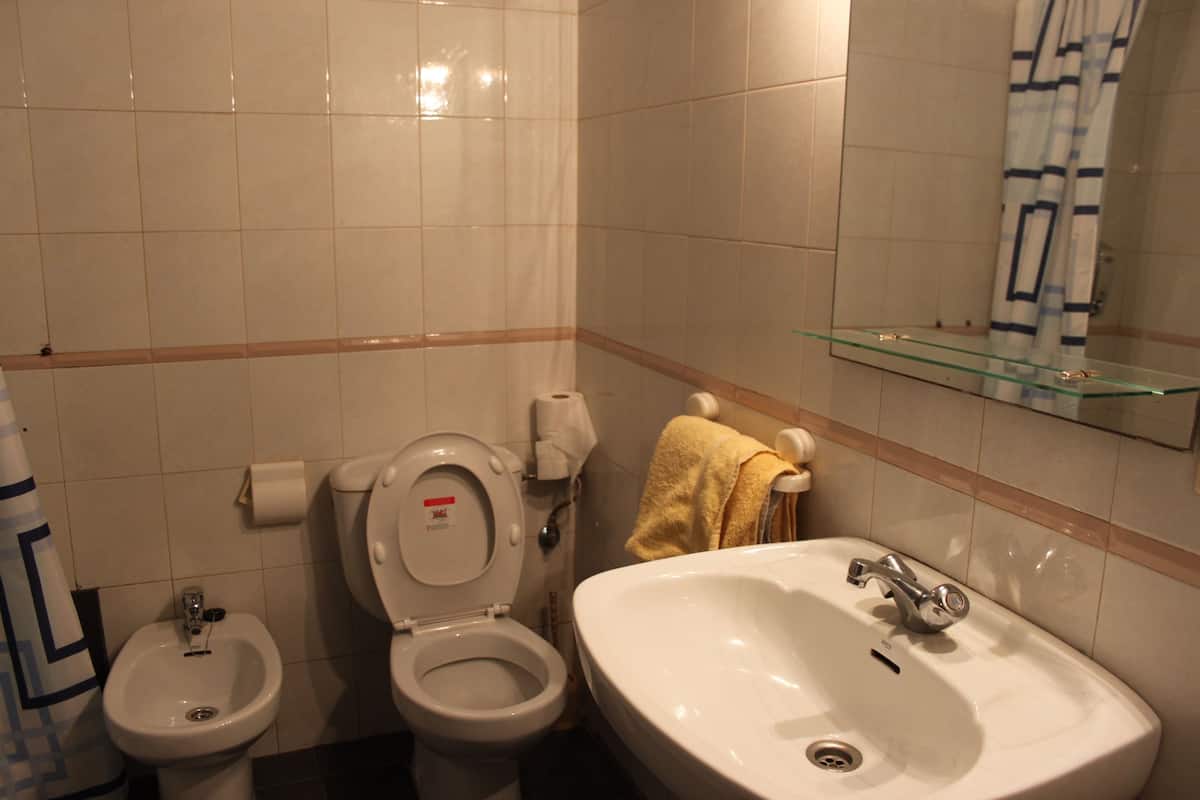 Un baño con inodoro, bidé y lavamanos.