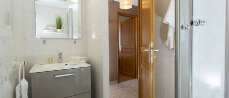 A modern bathroom with a mirror, sink, and towel rack.