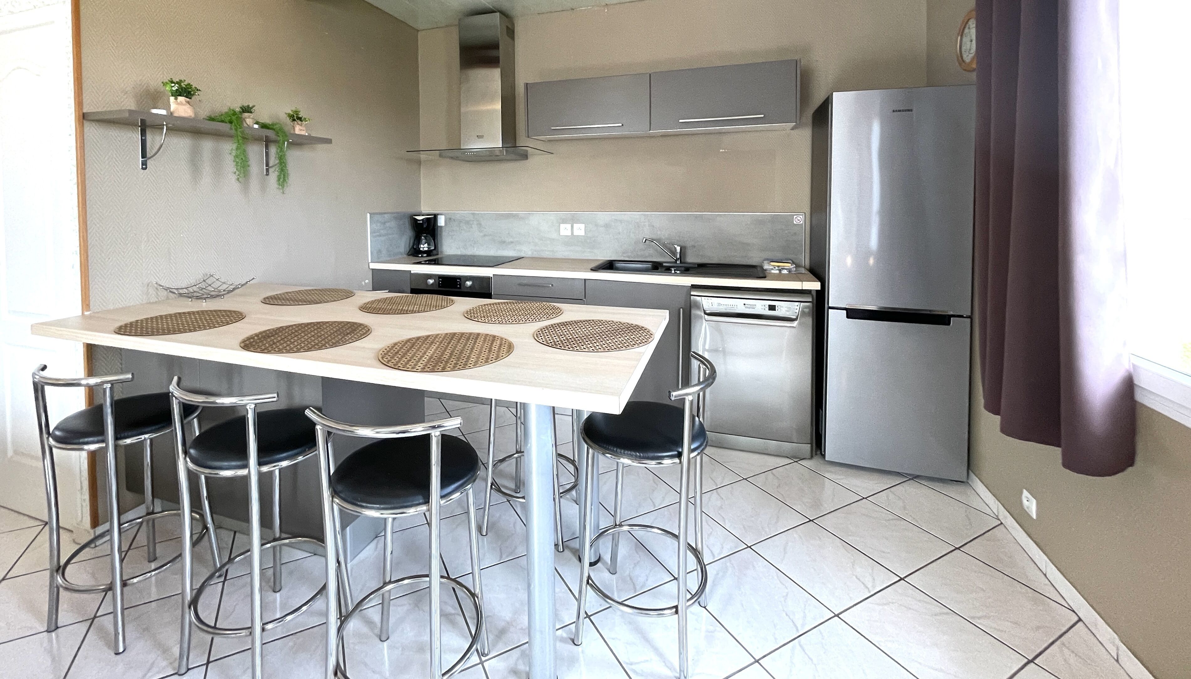 A compact kitchen with a dining area, stainless steel appliances, and a modern design.