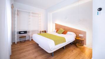 Un dormitorio con cama, armario, mesita de noche y lámpara de pared.