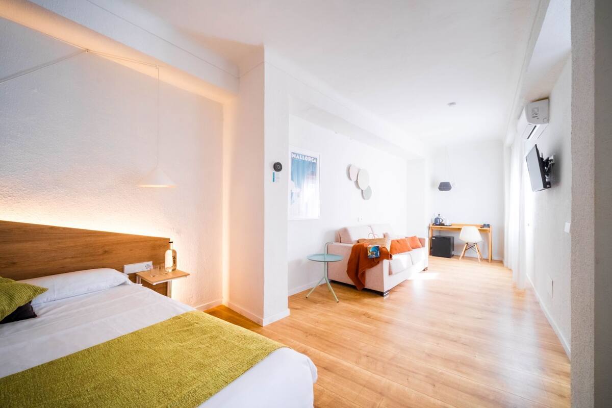 Una habitación de hotel con cama, mesita de noche y escritorio con silla.