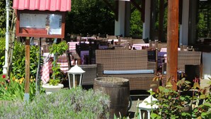 An outdoor seating area with umbrellas, wicker furniture, and a sign for "Pitt Dej Hotel". - The Originals City, Hotel Mulhouse, Ile Napoleon (Rixheim)