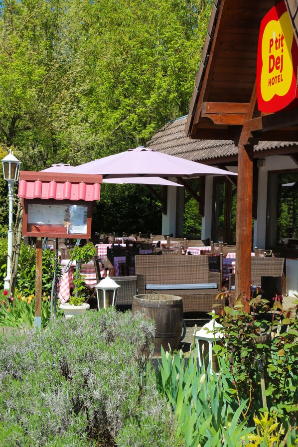 Relax in the hotel's serene garden setting, surrounded by lush greenery and comfortable wicker seating.