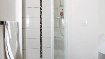 A bathroom with a glass-enclosed shower, a white toilet, and a towel rack.