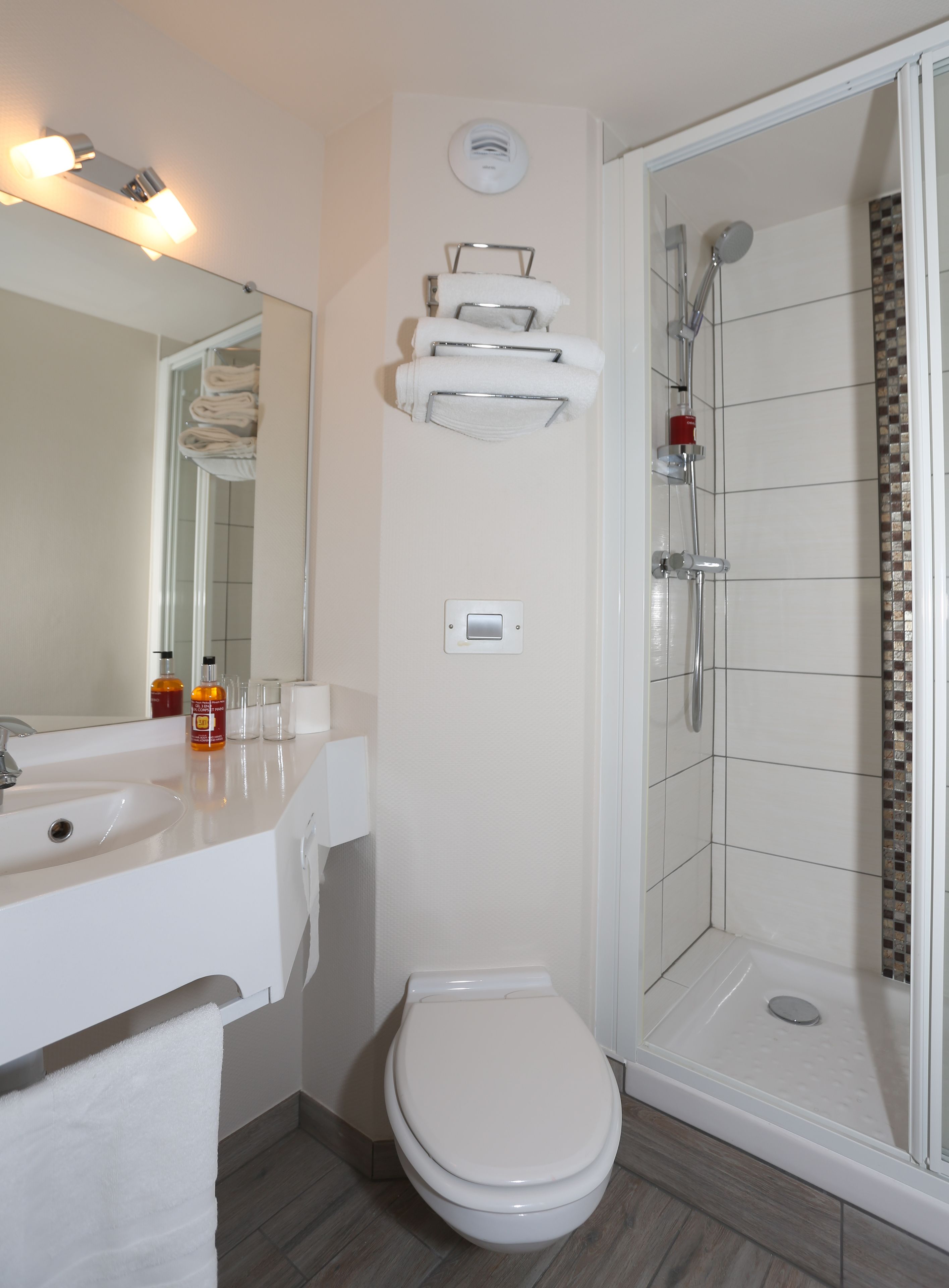 A modern bathroom with a shower, toilet, and sink.