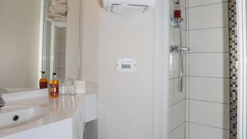 A modern bathroom with a shower, toilet, and sink.