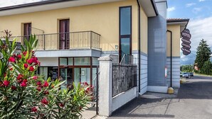 A hotel with a balcony, a sign indicating it offers a restaurant, and a view of the surrounding area. - Due Platani (Airuno)