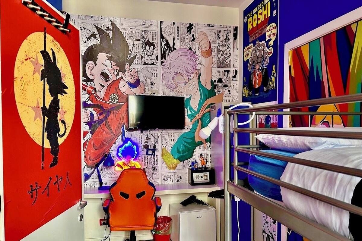A room with a bunk bed, a desk with a computer, and anime posters on the walls.