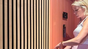 Una persona abre una puerta roja con una llave.