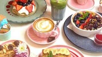 A variety of desserts and beverages on a table with a cherry blossom backdrop.