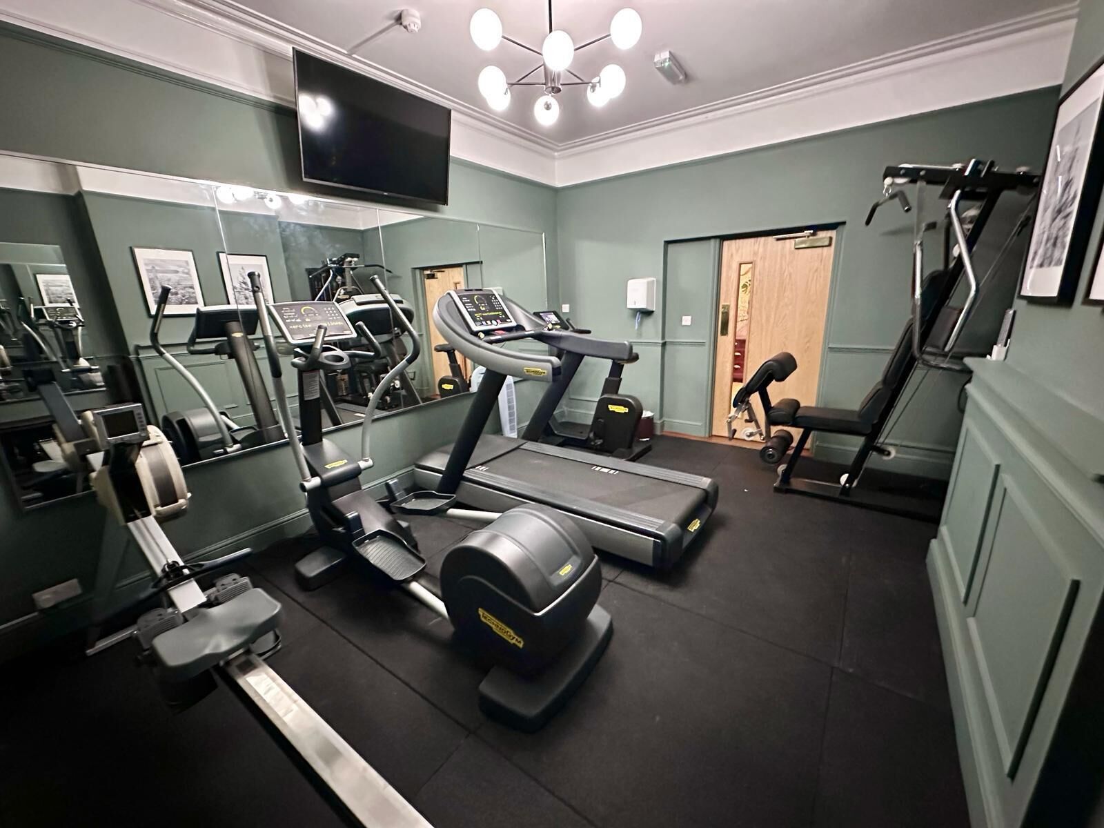 A gym with treadmills, elliptical machines, and weight benches.