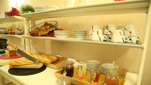 Una mesa de buffet con pan, salsas y vasos sobre estantes.
