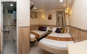 A hotel room with two beds, a bathroom, and a small table. - Lily Garden Guest House (Kowloon)