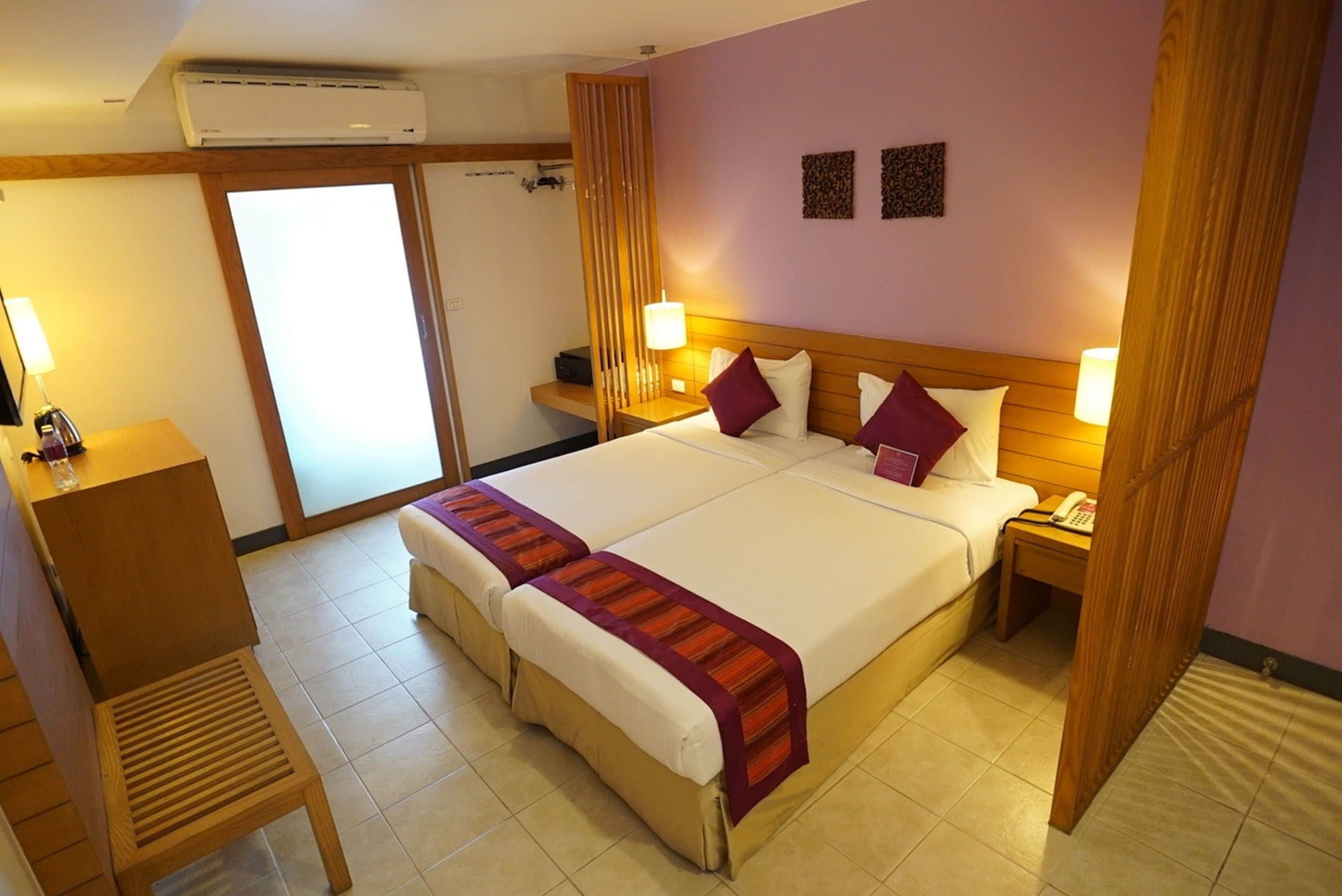 A hotel room with a large bed, bedside tables, a desk, and a chair.