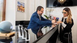A reception area with a reception desk, a framed picture on the wall, and a potted plant.
