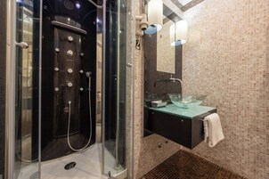 Une salle de bain moderne avec une douche à parois de verre, un lavabo en verre et un mur recouvert de carreaux.
