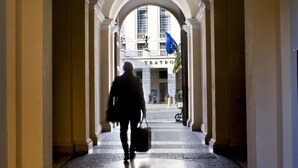 A corridor with arches leading to a building entrance.